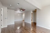 Located at 916 N Woodland St in Visalia, California, this well-appointed single-floor home offers a thoughtfully designed layout with a range of practical and attractive features throughout. The living area welcomes residents with warm wood-look flooring, an exposed beam accent, and a front entry flanked by a sidelight window that invites natural light into the space. An elegant three-light chandelier distinguishes the dining area, which also features the same rich hardwood-style flooring for a cohesive look. The bedrooms are finished with plush carpeting and equipped with ceiling fans for year-round comfort. Each bedroom benefits from generous closet space, including walk-in closets outfitted with wood-accented shelving and hanging rods. The bathrooms are finished with granite countertops, white cabinetry with oil-rubbed bronze hardware, large mirrors, and tile flooring. One bathroom features a tub-shower combination with tile surround and a window for natural light, while another includes a glass-door shower enclosure. A dedicated laundry closet with louvered bi-fold doors houses a full-size washer and dryer, conveniently located near the bedrooms. The home's neutral color palette and clean finishes create a bright, move-in ready environment throughout.