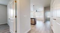 This single-floor unit showcases a clean, contemporary design with light wood-style flooring that runs consistently throughout the space, creating a cohesive and airy feel. The open-concept kitchen serves as a central hub, featuring dark espresso cabinetry paired with granite countertops, a kitchen island with an undermount sink, stainless steel appliances including a refrigerator, range, microwave, and dishwasher, and pendant lighting overhead. The layout flows naturally into a dining and living area bathed in natural light from multiple windows fitted with horizontal blinds.

The bedrooms are well-proportioned, each benefiting from natural light through generously sized windows, with ceiling fans providing additional comfort in key rooms. Closet space is included in the bedrooms for practical storage.

The bathroom is well-appointed with a dual-sink vanity topped with granite, dark cabinetry, a walk-in shower, and a walk-in closet with open shelving. A dedicated utility or flex space includes built-in cabinetry with granite countertops, open shelving above, and a large window overlooking the surrounding neighborhood. Neutral wall tones and consistent finishes lend the unit a polished, move-in-ready appearance.