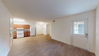 Located at 9393 Tidwell Rd in Houston, TX, this single-floor unit offers a practical and well-designed layout suited for comfortable everyday living. The open-concept living and dining area flows seamlessly into the kitchen, which is outfitted with warm honey-toned wooden cabinetry, granite-style countertops, a white refrigerator, a white range, and a stainless steel dishwasher. Light wood-style flooring runs throughout the main living areas, lending a clean and cohesive look. Natural light filters in through windows dressed with vertical blinds, brightening the spacious common areas. The bedrooms feature soft wall-to-wall carpeting and ceiling fans with integrated lighting, creating a comfortable and restful environment. Each room includes windows that allow for natural ventilation and light. The bathrooms are thoughtfully designed with wood-style flooring, a combined tub and shower, and accessibility-friendly grab bars. The primary bathroom features a wooden vanity with a granite-topped sink, a well-lit mirror, and a curved shower curtain rod. Clean white walls and neutral tones throughout the unit create a bright, move-in-ready atmosphere that is both functional and inviting.