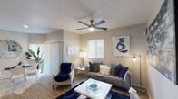This single-floor residence offers a thoughtfully designed layout that balances comfort and functionality across its key living spaces. The living room serves as the heart of the home, featuring wood-style flooring, a ceiling fan with light fixture, and generous natural light streaming through window blinds. A sliding glass door provides access to the exterior, while contemporary wall art and a neutral color palette create a welcoming ambiance. Adjacent to the living area, the dining space accommodates a round glass-top table and is brightened by a large window, with direct sightlines into the kitchen. The kitchen is well-equipped with white shaker-style cabinetry, dark countertops, stainless steel appliances including a range, microwave, and dishwasher, and a gray subway tile backsplash. The two bedrooms each feature ceiling fans, wood-style flooring, and natural light from windows with blinds. The primary bedroom includes a walk-in closet, while both rooms offer ample space for full-sized furniture. Two full bathrooms serve the residence, each appointed with a shower-tub combination, wood-style tile flooring, and clean, understated finishes. The consistent flooring and neutral tones throughout create a cohesive and move-in-ready living environment.