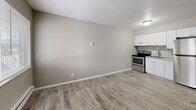 Located at 337 N Butler Ave in Marion, Indiana, this one-bedroom, one-bathroom unit offers an efficient and functional layout across a single floor. Light neutral walls and light-toned luxury vinyl plank flooring are consistent throughout the space, creating a cohesive and clean aesthetic.

The combined kitchen and living area forms the heart of the unit. The kitchen is equipped with white cabinetry, a stainless steel electric range, and light countertops with a tile backsplash, positioned along one wall to maximize the open feel of the living space. A window in the living area allows natural light to enter, while a baseboard heating unit runs along the exterior wall for climate control.

The bedroom is a well-proportioned room featuring a window with blinds for natural light and privacy, a wall-mounted air conditioning unit, and a baseboard heater. A dedicated walk-in closet with wire shelving and hanging rods provides practical storage. An additional door from the bedroom leads toward the bathroom and the rest of the unit.

The bathroom is finished with tile flooring and includes a full-size tub and shower combo with a white surround, a toilet, and a wall-mounted sink with tile accents. Throughout the unit, white trim and doors provide clean contrast against the neutral wall tones, contributing to a tidy and move-in-ready appearance.