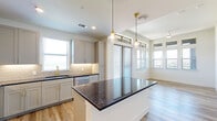 Located along E State Highway 121 N in Lewisville, TX, this thoughtfully designed 2-bedroom, 2-bathroom residence offers a comfortable and modern living experience across a single floor. The open-concept kitchen and living area serves as the heart of the home, highlighted by a central island with a striking dark granite countertop, elegant gold pendant lighting, soft gray shaker-style cabinetry, a classic subway tile backsplash, and stainless steel appliances. Light wood-style flooring flows throughout the main living areas, complementing the bright, neutral color palette. Large windows invite abundant natural light and connect seamlessly to a private balcony, where expansive open views of the surrounding Lewisville landscape create a serene outdoor retreat. A clean hallway with light wood flooring leads to the two carpeted bedrooms, each featuring windows with outdoor views and dedicated closets. The primary bedroom closet is outfitted with built-in shelving and hanging rods, offering well-organized storage. Both bathrooms are finished with refined touches, including a glass-enclosed shower adorned with marble-look tile and brass fixtures. The overall ambiance is clean, contemporary, and move-in ready.