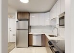 This thoughtfully updated 3-bedroom, 1-bathroom unit at 10030 114 Street NW offers a clean, modern aesthetic throughout its well-proportioned single-floor layout. Light wood laminate flooring flows through the living areas and bedrooms, complemented by crisp white walls and bright, airy rooms that benefit from natural light through large windows with urban views.

The contemporary kitchen is a standout feature, finished with a combination of white gloss upper cabinetry and warm wood-toned lower cabinets, light stone countertops, and marble-look porcelain tile flooring. It is equipped with a full suite of stainless steel appliances including a refrigerator, dishwasher, over-the-range microwave, and stove. The space transitions smoothly via hallways connecting all key areas.

The generously sized primary bedroom features mirrored sliding closet doors and baseboard heating, while the additional bedrooms offer clean, versatile spaces with ample natural light and windows overlooking the surrounding neighbourhood. The bathroom is elegantly appointed with marble-look tile extending from floor to tub surround, a soaker tub with overhead shower, and chrome fixtures throughout. The entrance provides a welcoming transition into the unit, rounding out a well-organized and functional floor plan.