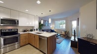 Located at 6777 Golden Gate Dr in Dublin, California, this single-floor residence showcases a thoughtfully designed open-concept layout that seamlessly connects the kitchen, dining, and living areas. The kitchen is outfitted with two-tone cabinetry—combining high-gloss white upper cabinets with warm wood-grain lower cabinets—paired with white quartz countertops and a full suite of stainless steel appliances, including a refrigerator, range, microwave, and dishwasher. Pendant lighting above the peninsula adds a modern touch, while recessed lighting illuminates the space evenly. Light-toned tile flooring runs through the kitchen and transitions into rich hardwood flooring in the living area.

The living room benefits from natural light streaming through a large window with outdoor views of surrounding greenery, creating a bright and welcoming atmosphere. The bedroom is a calm retreat with plush carpeting, a sizable window, and a spacious walk-in closet outfitted with wire shelving and hanging rods for ample storage. The bathroom features a full soaking tub with tile surround, clean white fixtures, and tile flooring, maintaining the unit's consistent modern aesthetic throughout.