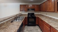 Located at 50 Rocky Creek Rd in Greenville, SC, this single-floor residence offers a thoughtfully designed layout with comfortable, functional living spaces throughout. The kitchen is equipped with rich cherry wood cabinetry, granite-style countertops, a double stainless steel sink, and black appliances including an electric range, providing ample storage and workspace for everyday cooking. The open living area features warm, neutral-toned carpet, a ceiling fan with light fixture, and a sliding glass door dressed with vertical blinds that invites natural light and provides access to the outdoors. Additional carpeted rooms serve as generously sized bedrooms, each with ceiling fans, natural light from windows, and textured ceilings that add a classic touch. The floor plan, visible in the dollhouse view, reveals a well-organized layout with clear separation between living, sleeping, and utility spaces. The master bathroom stands out as a highlight, showcasing wood-look luxury vinyl plank flooring, a double-sink vanity with granite-style countertops and rich cabinetry, a large soaking tub, and a full-width mirror with globe lighting — creating a refined and relaxing atmosphere.