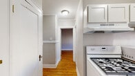 Located at 357 Morris St in Albany, NY, this 2-bedroom, 1-bathroom residence offers a classic and functional single-floor layout with timeless architectural details throughout. Warm hardwood floors run consistently across the living spaces, complemented by crisp white crown molding and neutral gray walls that create a clean, cohesive aesthetic.

The primary bedroom is a comfortable and well-proportioned room featuring decorative wall panel molding, a ceiling fan, a closet, and large windows with a street view that allow natural light to fill the space. A cast-iron radiator provides traditional heating. The second bedroom is similarly appointed with hardwood floors, a window with neighborhood views, a radiator, and crown molding.

The kitchen is efficiently designed with white cabinetry, granite-style countertops, a gas range with overhead ventilation, a full-size refrigerator, and a window with a street-facing view. A radiator and wainscoting-style lower wall detail add character to the space. A hallway connects the rooms, featuring flush ceiling lighting and easy access to all areas of the home.

The bathroom is neatly finished with white tile walls surrounding a full bathtub and shower, a toilet, patterned tile flooring, and a window for ventilation and natural light. Throughout the home, the blend of classic detailing and practical amenities makes for a well-rounded and inviting living space.