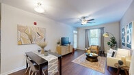 Located at 1001 Hayes Ln in Holly Springs, NC, this single-floor, 2-bedroom, 2-bathroom residence offers a thoughtfully designed layout that balances comfort and functionality. The open-concept living, dining, and kitchen area forms the heart of the home, anchored by rich hardwood-style flooring and ceiling fans that enhance the bright, airy atmosphere. Large windows invite generous natural light and offer pleasant outdoor views, while neutral wall tones create a warm, welcoming ambiance throughout.

The kitchen features rich cherry-toned cabinetry, dark countertops, a classic tile backsplash, and black appliances, offering ample storage and prep space in a galley-style configuration. Both bedrooms are carpeted and generously sized, each with its own distinct character — one highlighted by a soft blue accent wall, the other by a serene sage green tone. The spacious primary bedroom includes a large walk-in closet with wire shelving.

Both bathrooms are well-appointed, with rich wood vanities, hardwood-style flooring, and a tub-shower combination. A dedicated in-unit laundry room houses a full-size washer and dryer. Three closets throughout the home provide excellent storage. This residence offers a complete, move-in-ready living experience in a desirable Holly Springs location.