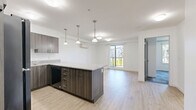 Located at 2699 Peatt Rd in Langford, BC, this one-bedroom, one-bathroom unit offers a well-designed layout across a single floor. The kitchen is a standout feature, showcasing rich dark wood cabinetry, granite countertops, black appliances including a range and built-in microwave, and a large peninsula with pendant lighting overhead — ideal for both cooking and casual dining. Light wood-look flooring runs through the main living areas, contributing to a bright and clean aesthetic. The bedroom is a comfortable, private retreat with patterned carpet tile flooring and a wall-mounted ductless mini-split heating and cooling unit, ensuring year-round climate comfort. The bathroom is finished with a dark wood vanity accented by granite countertops and brushed nickel hardware, complementing the overall contemporary style of the unit. A dedicated laundry area includes a full-sized top-load washer and dryer, along with additional storage shelving — a practical and convenient inclusion. Clean white walls and crisp trim throughout the space lend a fresh, modern feel. This unit offers a functional and cohesive design with quality finishes that make everyday living both comfortable and stylish.