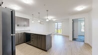 Located at 2699 Peatt Rd in Langford, BC, this one-bedroom, one-bathroom unit offers a well-designed layout across a single floor. The kitchen is a standout feature, showcasing rich dark wood cabinetry, granite countertops, black appliances including a range and built-in microwave, and a large peninsula with pendant lighting overhead — ideal for both cooking and casual dining. Light wood-look flooring runs through the main living areas, contributing to a bright and clean aesthetic. The bedroom is a comfortable, private retreat with patterned carpet tile flooring and a wall-mounted ductless mini-split heating and cooling unit, ensuring year-round climate comfort. The bathroom is finished with a dark wood vanity accented by granite countertops and brushed nickel hardware, complementing the overall contemporary style of the unit. A dedicated laundry area includes a full-sized top-load washer and dryer, along with additional storage shelving — a practical and convenient inclusion. Clean white walls and crisp trim throughout the space lend a fresh, modern feel. This unit offers a functional and cohesive design with quality finishes that make everyday living both comfortable and stylish.