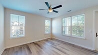 This well-appointed 2-bedroom, 2-bathroom home at 500 Verdant Way in Charleston, SC offers a thoughtfully designed single-floor layout with a clean, modern aesthetic. The open-concept living and kitchen area serves as the heart of the home, featuring warm hardwood-style flooring, a ceiling fan, and abundant natural light. The kitchen is equipped with white shaker-style cabinetry, stainless steel appliances including a refrigerator, dishwasher, and range, along with a kitchen island, open wood shelving, and matte black hardware accents throughout.

Both bedrooms are generously sized, with ceiling fans, large windows that bring in natural light, and plush carpeting underfoot. The primary bedroom includes access to one of five closets, which feature built-in wire shelving systems for organized storage. A dedicated laundry room and pantry add to the home's practical functionality.

The bathrooms are finished with a crisp, contemporary style. One bathroom showcases a marble-look tiled tub surround, a white vanity with under-mount sink, and coordinating matte black fixtures and hardware. Light hardwood-style flooring carries through the wet areas seamlessly.

Crisp white walls, panel-style doors with matte black hardware, and recessed lighting complete the modern, cohesive interior design throughout this Charleston home.