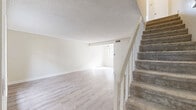 Located in Santa Clarita, CA, this two-story, 2-bedroom, 2-bathroom home offers a clean, neutral aesthetic with thoughtful layout across two well-proportioned floors. The main level welcomes you with light wood-style flooring that flows through the open living and dining areas, filling the space with a bright, airy feel. Natural light pours in through large windows, enhancing the home's crisp, white walls and textured ceilings. A carpeted staircase with white-painted railings connects the two levels. The kitchen features white cabinetry, ample counter space, and a full suite of stainless steel appliances including a range, microwave, and refrigerator, complemented by light wood flooring and a skylight overhead. Upstairs, both bedrooms are carpeted and generously sized, each equipped with sliding-door closets for practical storage. The primary bedroom offers serene outdoor views through a large window. The bathrooms are finished in light, neutral tones, with the upper bath showcasing a white vanity, wood-look tile flooring, and a frosted privacy window. With four closets distributed throughout, the home provides ample storage. The consistent use of soft neutrals and natural light throughout creates a calm, welcoming atmosphere.