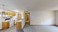 Located at 28 Sterling Ridge Dr in Delaware, Ohio, this well-organized 2-bedroom, 1-bathroom residence offers a practical single-floor layout designed for comfortable everyday living. The open living area features durable wood-look vinyl flooring and flows seamlessly into a half-wall peninsula kitchen equipped with warm honey-toned wood cabinetry, white appliances including an electric range and refrigerator, and ample counter space. A pendant chandelier illuminates the adjacent dining area, which connects to the main entry door. A hallway leads from the living space to the private areas of the home, where both bedrooms feature plush carpet flooring, neutral walls, and windows that provide natural light and views of surrounding greenery. The primary bedroom includes a spacious walk-in closet with wire shelving, while a second closet with sliding doors and built-in rod offers additional storage. The full bathroom is appointed with a single-sink vanity with wood cabinetry, a toilet, and a tub-shower combination. A textured ceiling is present throughout. The unit also includes a dedicated laundry area and benefits from a clean, neutral color palette throughout, making it a versatile and move-in ready space.