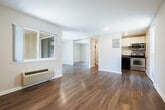 Located at 530 N Civic Dr in Walnut Creek, California, this efficiently designed single-floor unit offers a clean, modern aesthetic throughout its thoughtfully arranged layout. The living room serves as the centerpiece of the space, showcasing warm wood-look flooring that extends seamlessly across the entire unit, creating a sense of cohesion and continuity. Neutral, light gray walls complement the bright interior, reflecting natural light and contributing to an open, airy feel. A set of sliding glass doors in the living area opens to a private outdoor patio, allowing abundant natural light to pour in while providing easy indoor-outdoor access. A wall-mounted HVAC unit ensures year-round climate comfort. Recessed lighting adds a polished touch to the interior. The bathroom features durable wood-look flooring consistent with the rest of the unit, white panel doors, and accessibility-friendly grab bars, reflecting both practicality and thoughtful design. A side window in the living area further brightens the space, enhancing the overall sense of openness. Clean white trim and baseboards throughout frame each room neatly, underscoring the unit's well-maintained, move-in-ready condition.