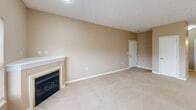 Located at 21 Stockton Ridge in Cranberry Township, PA, this two-bedroom, two-bathroom residence offers a comfortable and functional single-floor layout with a warm, neutral aesthetic throughout. The open living area is a standout, featuring plush carpeting, a corner fireplace, and a large window that invites natural light. Sliding glass doors with vertical blinds lead to an outdoor area, further brightening the space. The combined kitchen and living room area is thoughtfully designed, with the kitchen showcasing white cabinetry, white appliances, recessed lighting, and a peninsula with a sink that overlooks the main living space — ideal for both cooking and entertaining. The primary bedroom is generously sized, featuring a ceiling fan, a large window, and access to a walk-in closet outfitted with extensive wire shelving and hanging rods for organized storage. The second bedroom also offers carpeted flooring and a ceiling fan. Both bathrooms are clean and functional, with one featuring a full soaking tub and shower combination. A dedicated in-unit laundry area adds everyday convenience. A hallway connects the rooms efficiently, completing this well-organized and comfortable Cranberry Township residence.