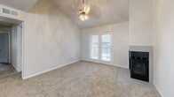 Located at 7414 E Grand Ave in Dallas, TX, this two-bedroom, one-bathroom unit offers a well-designed single-level layout. The living room is anchored by soaring vaulted ceilings, a ceiling fan light fixture, a cozy fireplace, and French doors that open to a private patio, allowing natural light to fill the space. Plush carpet flows throughout the living and bedroom areas, while wood-look flooring defines the kitchen and dining zones.

The open-concept kitchen and dining area is thoughtfully appointed with dark espresso cabinetry, a subway tile backsplash, granite countertops extending into a peninsula with an undermount sink, and a full suite of stainless steel appliances. A stylish chandelier overhead adds an elegant touch to the dining space.

The primary bedroom is generously sized and features access to a walk-in closet with built-in shelving. The second bedroom offers comfortable proportions with its own closet. Additional storage is provided through multiple closets and a pantry throughout the unit. A dedicated laundry area adds everyday convenience.

The bathroom is finished with granite countertops, dark wood cabinetry with brushed nickel hardware, wood-look tile flooring, and a tiled tub-shower combo. A hallway connects the main living areas to the private bedroom wing, completing this functional and stylish layout.