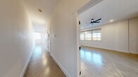 Located at 231 E 25th St in Little Rock, Arkansas, this single-story 1-bedroom, 1-bathroom home offers a thoughtfully designed modern interior with a clean, minimalist aesthetic throughout. Polished concrete floors run seamlessly across the entire space, reflecting natural light and contributing to the home's contemporary character.

The open-concept living, dining, and kitchen area forms the heart of the home. The kitchen stands out with striking green ceramic tile backsplash, light wood cabinetry, sleek countertops, a stainless steel range with a wall-mounted hood, and a stainless steel refrigerator — all centered around a functional island. A pantry provides additional storage, and natural light filters in through multiple windows.

A long hallway connects the main living areas to the private spaces, including the generously sized bedroom, which features polished concrete floors, a ceiling fan, recessed lighting, and large multi-pane windows that flood the room with natural light and offer open views. A two-tone accent wall adds a distinctive design touch to the bedroom.

The bathroom is outfitted with a wood-toned vanity, tiled tub-surround, and matte black fixtures. Additional practical spaces include a dedicated laundry room, utility room, closet, and hallway. This home combines industrial-modern design with functional everyday living.