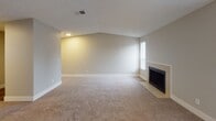 Located in Federal Way, WA, this single-floor unit at 32105 20th Ln SW offers a thoughtfully arranged layout with a variety of functional spaces throughout. The living room is a standout area, featuring vaulted ceilings, plush carpeting, a classic fireplace, and a window that brings in natural light, creating a warm and inviting atmosphere. A ceiling fan in the open adjoining area aids in comfort and airflow, while the space flows naturally toward the kitchen. The kitchen is well-equipped with crisp white shaker-style cabinetry, light granite-style countertops, a stainless steel range, and wood-look flooring, providing a clean and modern cooking environment. The bedroom is generously sized, finished with soft carpeting, neutral-toned walls, and a window with blinds for privacy. An additional room with carpeting and a textured ceiling offers flexible use as a second bedroom, office, or den. The bathroom features a white vanity with granite-style counters, brushed nickel hardware, a large mirror with overhead lighting, and dark wood-look flooring. A utility closet houses the water heater, and a carpeted hallway with a thermostat connects the various rooms efficiently. The overall aesthetic is clean, neutral, and move-in ready.
