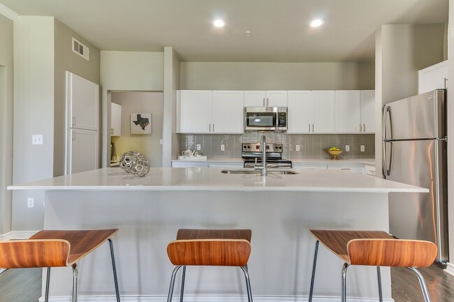 Stunning kitchens include quartz countertops and custom-patterned tile backsplash. - Windsor at Legacy