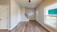 Located at 103 Stoneledge Ct in Elizabethtown, Kentucky, this two-story home offers 2 bedrooms and 3 bathrooms across two well-proportioned floors. The main level features an open-concept kitchen and living room with durable hardwood-style plank flooring that extends throughout. The kitchen is appointed with white shaker-style cabinetry, granite-look countertops, stainless steel appliances including a range, microwave, dishwasher, and refrigerator, plus a stainless steel sink. A stylish staircase with decorative iron balusters connects the two floors. Upstairs, the bedrooms are finished with plush carpet and ceiling fans, and each room features large windows that allow ample natural light and views of the surrounding neighborhood. The primary bedroom is a comfortable size with its own dedicated bathroom. The three bathrooms are clean and well-appointed, featuring white vanities with granite-look countertops, tub-shower combinations, and hardwood-style flooring. Additional highlights include a walk-in closet area, a hallway connecting the upper-level rooms, and a neutral warm color palette throughout that lends the home a bright, welcoming ambiance.