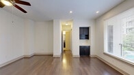 Located at 3521 Wilshire Way in Richardson, TX, this well-designed one-bedroom, two-bathroom residence offers a functional and modern living experience across a single floor. Rich, dark hardwood flooring flows throughout the main living areas, creating a warm and cohesive aesthetic complemented by clean white walls and recessed lighting.

The open-concept kitchen and living area serves as the heart of the home. The kitchen is equipped with dark espresso cabinetry, stainless steel appliances including a French door refrigerator and microwave, a tile backsplash, and a sleek white peninsula countertop with pendant lighting overhead — ideal for casual dining or entertaining. A built-in niche with cabinetry and a wine rack adds a distinctive design touch to the living area.

Large windows allow natural light to fill the space, while a ceiling fan provides added comfort. The hallways are well-lit and connect seamlessly to the bedroom, closets, and bathrooms.

The primary bedroom features plush carpet flooring, a ceiling fan, and access to a spacious en-suite bathroom complete with a dual-sink vanity featuring dark cabinetry and stone countertops. A second bathroom includes a soaking tub with tile surround and a built-in niche. Two generous walk-in closets with built-in shelving provide ample storage throughout the home.