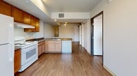 This 500 square foot apartment in Longmont, Colorado, offers a thoughtful blend of comfort and efficiency. The single-floor layout comprises one bedroom, one bathroom, and an open-concept living area. The primary bedroom, measuring 120 square feet, provides ample space for rest and relaxation.

The interior boasts modern finishes throughout, with sleek wood-look flooring unifying the space. The kitchen features warm wood cabinetry, contrasting white appliances, and a practical island, creating an inviting cooking area that flows seamlessly into the living space. Large windows allow natural light to flood the rooms, enhancing the sense of openness.

The bathroom is designed for convenience, with a full-sized washer and dryer cleverly integrated alongside essential fixtures. Built-in storage solutions, including sliding closet doors in the bedroom, maximize the use of available space.

A notable feature is the apartment's connection to its urban surroundings, with windows offering views of neighboring buildings. The efficient floor plan demonstrates smart space utilization, making this compact apartment feel surprisingly spacious and livable. Located at 518 Coffman St, this property presents an ideal option for those seeking a modern, low-maintenance living space in the heart of Longmont.