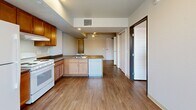 Located at 518 Coffman St in Longmont, CO, this one-bedroom, one-bathroom unit offers a smart, well-organized layout across a single floor. Warm hardwood-style flooring flows throughout the entire space, creating a cohesive and inviting atmosphere.

The open-concept living and kitchen area is a highlight of the unit. The kitchen features warm-toned wood cabinetry, a peninsula with an overhang ideal for bar seating, a full-size refrigerator, electric range, dishwasher, and ample counter space. A ceiling fan overhead keeps the living area comfortable, while vertical blinds frame a sliding glass door that fills the space with natural light and provides outdoor access.

The bedroom is a well-proportioned private retreat, offering a large sliding double-door closet, a window with views of the surrounding neighborhood, and a secondary transom-style window for added light. Three closets throughout the unit provide generous storage options.

The bathroom is efficiently designed and shares space with a dedicated in-unit laundry area, complete with a stacked washer and dryer — a convenient and practical feature. Warm wood cabinetry in the bathroom complements the finishes found throughout the unit.

Overall, this space presents a clean, modern aesthetic with functional design choices that maximize every square foot of the layout.