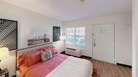 Located at 4515 Apex Hwy in Durham, NC, this efficiently designed studio-style unit offers a thoughtful single-floor layout that maximizes every square foot. The main living area serves as the bedroom, featuring hardwood-style flooring, a large window with blinds that invites natural light, and a wall-mounted PTAC unit for personalized climate control. The space comfortably accommodates a full-size bed alongside a wooden dresser, providing practical storage within the living area.

A built-in counter with cabinetry acts as a natural divider between the sleeping area and the kitchenette, doubling as a convenient prep or dining surface. The kitchenette is outfitted with white cabinetry, a refrigerator, a sink, and overhead lighting, offering essential cooking functionality in a compact footprint.

The bathroom is clean and straightforward, featuring wood-style flooring, a wide vanity with an integrated sink, a large framed mirror with overhead lighting, and a toilet — all presented in a bright, neutral palette.

Throughout the unit, the white walls and consistent flooring create a cohesive, airy feel. This space is well-suited for individuals seeking a practical, self-contained living environment in the Durham, NC area.