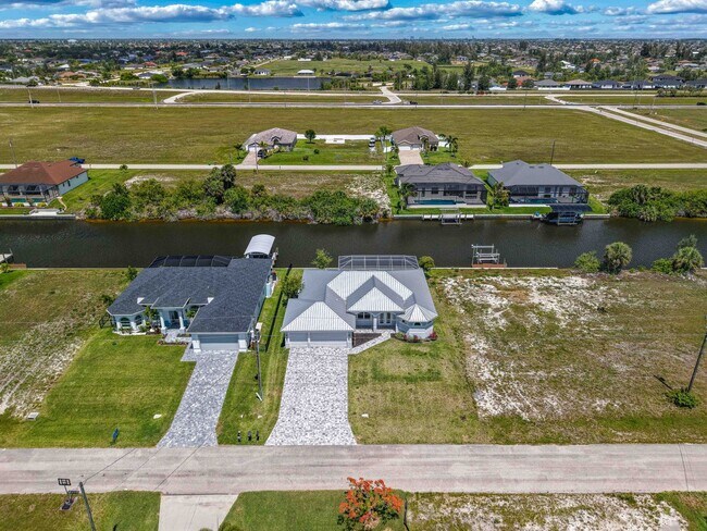Building Photo - NOW AVAILABLE - Gorgeous Pool Home ~ NW Cape ~ 3 Car Garage ~ On Canal!