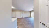 Located at 8001 E 11th Ave in Denver, CO, this well-appointed 1-bedroom, 1-bathroom unit offers a thoughtfully designed layout across a single floor. The living room is a standout space, showcasing rich wood-style flooring, a tile-surround fireplace, and a sliding glass door that fills the room with natural light and opens to a private balcony with views of mature trees and the surrounding community. The kitchen is a true highlight, featuring crisp white cabinetry, white quartz countertops, a striking black hexagonal tile backsplash, stainless steel appliances including a range, over-the-range microwave, and refrigerator, plus a peninsula that connects seamlessly to the dining area. The bedroom offers plush carpeting, a bright window with blinds, and generous closet space with double bifold doors. The bathroom is clean and functional, appointed with white cabinetry, a large vanity mirror with modern light fixtures, and a tub/shower combination with tiled surround. Wood-style flooring extends through the bathroom as well. Additional conveniences include in-unit laundry, a utility room, and ample storage. Neutral warm tones throughout create a cohesive and inviting ambiance.
