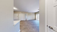 Located at 8001 E 11th Ave in Denver, CO, this well-appointed 1-bedroom, 1-bathroom unit offers a thoughtfully designed layout across a single floor. The living room is a standout space, showcasing rich wood-style flooring, a tile-surround fireplace, and a sliding glass door that fills the room with natural light and opens to a private balcony with views of mature trees and the surrounding community. The kitchen is a true highlight, featuring crisp white cabinetry, white quartz countertops, a striking black hexagonal tile backsplash, stainless steel appliances including a range, over-the-range microwave, and refrigerator, plus a peninsula that connects seamlessly to the dining area. The bedroom offers plush carpeting, a bright window with blinds, and generous closet space with double bifold doors. The bathroom is clean and functional, appointed with white cabinetry, a large vanity mirror with modern light fixtures, and a tub/shower combination with tiled surround. Wood-style flooring extends through the bathroom as well. Additional conveniences include in-unit laundry, a utility room, and ample storage. Neutral warm tones throughout create a cohesive and inviting ambiance.