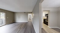 Located at 725 Mansion Cir in Chattanooga, TN, this single-story home offers a well-organized, functional layout designed for comfortable everyday living. The main living area is generously sized, featuring warm-toned hardwood-style flooring, neutral gray walls, and a textured ceiling. A hallway connects the living space to the private rooms, maintaining a clear and practical flow throughout the home.

The kitchen is efficiently designed with crisp white cabinetry extending to the ceiling, speckled countertops, a stainless steel sink, and black appliances including a full-size refrigerator, range, and dishwasher. A pass-through window connects the kitchen to the living area, enhancing the open feel. An adjacent dining area with a pendant light offers a defined space for meals.

The bedrooms feature plush carpet flooring and ceiling fans, with one bedroom offering direct access to a bathroom equipped with a white vanity, speckled countertop, and a full tub-shower combination. Closets with louvered doors and built-in rods provide ample storage. A dedicated laundry area houses the water heater and washer/dryer hookups. Sliding glass doors lead to a private outdoor patio, bringing in natural light and outdoor views.
