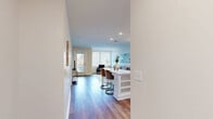 Located at 4301 Old William Penn Highway in Pittsburgh, PA, this thoughtfully designed one-bedroom, one-bathroom residence offers a clean, modern aesthetic throughout its efficiently arranged single-floor layout. Warm hardwood-style flooring flows through the open-concept living and kitchen areas, creating a cohesive and inviting atmosphere brightened by recessed lighting and large windows. The kitchen is outfitted with crisp white shaker cabinetry, white quartz countertops, a subway tile backsplash, and a full suite of stainless steel appliances, including a French door refrigerator, electric range, and built-in microwave. A white peninsula with open shelving provides seating and additional prep space. The living room is bright and comfortable, with natural light filtering through oversized windows. The bedroom features plush carpeting, a generous window with exterior views, and direct access to a hallway with a stacked in-unit washer and dryer. A walk-in closet with wire shelving provides practical storage. The bathroom includes a white vanity, classic black-and-white mosaic tile flooring, and a shower/tub combination. The property also features an outdoor covered terrace with stone columns and iron railing, offering a pleasant communal outdoor area.