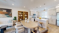 Located at 1483 W Vista Way in San Pedro, CA, this contemporary multi-story home spans three floors and offers a well-organized layout designed for both comfort and functionality. The entry level provides a welcoming entrance with light wood-tone flooring and crisp white walls that carry throughout the home. The main living floor features an open-concept arrangement combining the living room, dining area, and kitchen. The living room is bright and airy, with a ceiling fan, recessed lighting, and sliding glass doors opening to a balcony with outdoor views. The kitchen is outfitted with white shaker cabinetry, stainless steel appliances including a refrigerator and dishwasher, white quartz countertops, a deep undermount sink, and a central island with pendant lighting. The dining area comfortably accommodates a full-sized table. A dedicated office with a large window provides a productive workspace. The two bedrooms each feature light-filled windows, with the primary bedroom offering generous proportions and walk-in closet storage. Four full bathrooms are distributed across the floors, each finished cleanly with tub-shower combinations and light wood flooring. The home's consistent use of light tones, modern fixtures, and wood-look flooring creates a cohesive, contemporary ambiance throughout.