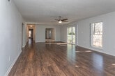 Located in the Waterfall Village community of Marietta, Georgia, this single-floor residence offers a well-organized layout with a clean, neutral aesthetic throughout. Rich, dark hardwood-style flooring flows consistently across the living areas and bedrooms, creating a warm and cohesive look.

The living room is generously proportioned, bathed in natural light from large sliding glass doors that open onto a private deck overlooking a wooded outdoor setting. A ceiling fan overhead adds both function and style to this bright, open space.

The kitchen is thoughtfully appointed with white shaker-style cabinetry, white quartz-look countertops, a classic subway tile backsplash, and stainless steel appliances including a gas range with an overhead vent hood. Ample cabinet storage and counter space make this kitchen both practical and visually appealing.

The bedrooms are well-sized, with neutral wall tones, hardwood-style flooring, and good natural light. One bedroom features a ceiling fan and access to an ensuite bath. The bathrooms are finished in crisp white, featuring tub-shower combinations with tile surrounds, white vanities with mirrors, and light wood-tone flooring, delivering a clean and functional design. The overall ambiance of the residence is bright, tidy, and move-in ready.