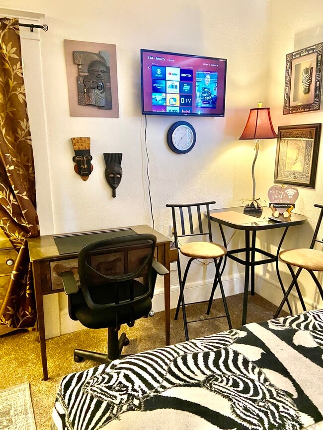 Cada estudio cuenta con un escritorio, una mesa de comedor o ambas cosas. - The Lindsay Furnished Apartments