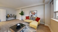 This thoughtfully designed 2-bedroom, 1-bathroom unit offers a comfortable and functional layout across a single floor. Light-toned hardwood flooring flows seamlessly throughout, lending a clean, cohesive aesthetic to the entire space.

The open-concept kitchen is a standout feature, equipped with stainless steel appliances including a refrigerator, stove, built-in microwave, and dishwasher, all complemented by crisp white shaker cabinetry and light countertops. A kitchen island provides additional prep space and casual seating. Notably, a stacked in-unit washer and dryer is neatly integrated within a dedicated cabinetry enclosure in the kitchen area.

The living room is bright and spacious, benefiting from a large window that invites generous natural light and offers views of the surrounding urban landscape. The room provides ample space for comfortable furnishings and everyday living.

The primary bedroom features a large window with outdoor views and room for a full bedroom set. The second bedroom is equally well-lit, with its own window and a built-in sliding-door closet for convenient storage. Both bedrooms feature the same warm hardwood flooring found throughout the unit.

The bathroom is finished with clean white subway tile surrounding a full soaker tub and shower combination, paired with a white vanity for a bright, timeless look. Two hallways connect the rooms efficiently, completing this well-organized layout.