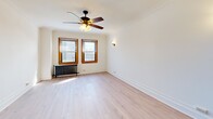 Located at 2738 N Pine Grove Ave in Chicago's desirable Lincoln Park neighborhood, this two-bedroom, one-bathroom unit offers a practical and well-appointed layout across a single floor. Light-toned hardwood floors run throughout the space, creating a cohesive and clean aesthetic from room to room.

Both bedrooms are comfortably sized, each featuring ceiling fans with integrated lighting, classic cast-iron radiators, warm wood-trimmed windows that allow natural light, and crown molding details. The primary bedroom is notably spacious and includes a large built-in closet with a full-width hanging rod. The second bedroom similarly benefits from a ceiling fan and radiator heating.

The kitchen is efficiently designed, featuring dark espresso cabinetry, granite countertops, a white subway tile backsplash, a stainless steel sink, a gas range, built-in microwave, and a dishwasher — providing strong functionality within a compact footprint.

The bathroom is finished with full white tile walls, a walk-in shower with brushed nickel fixtures, a classic basketweave tile floor, and a pedestal sink, offering a clean, timeless look. The unit includes one dedicated closet for additional storage. Overall, the space combines classic Chicago architectural character with updated finishes.