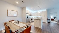 Located in Fort Mill, SC, this single-floor residence at 920 Yorkmont Ridge Lane offers a well-designed, open-concept layout with contemporary finishes throughout. The kitchen serves as a central hub, outfitted with white shaker-style cabinetry extending to the ceiling, under-cabinet lighting, stainless steel appliances, a subway tile backsplash, and a large center island topped with granite countertops. Pendant lighting above the island adds a polished touch, while wood-look flooring flows seamlessly into the adjacent dining area, which comfortably accommodates a full dining table.

The living area is bright and airy, benefiting from multiple windows that invite natural light. A ceiling fan and access to an outdoor area enhance the room's functionality and comfort. A dedicated home office features a large window with an outdoor view, providing a well-lit and productive workspace with plush carpeting underfoot.

The bathroom is finished with granite countertops, white cabinetry, wood-look tile flooring, and a tiled tub-shower combination. A dedicated laundry room houses a full-size washer and dryer with overhead shelving for added storage. Neutral tones and recessed lighting throughout give the entire space a clean, modern, and cohesive aesthetic.