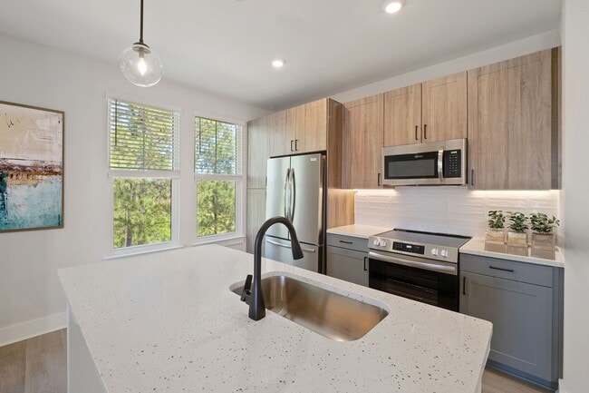 Elegant finishes including luxury vinyl plank flooring, contemporary kitchens, tile backsplash, stainless steel appliances and Quartz countertops - The Henslow Daniel Island Apartments & Townhomes