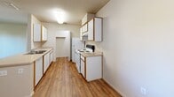 Located at 3301 Cimmarron Rd in Cameron Park, CA, this one-bedroom, one-bathroom unit offers a practical and efficiently designed single-floor layout. The space is organized to maximize functionality across its compact footprint, with a hallway connecting the primary living areas.

The galley-style kitchen is a standout feature, lined on both sides with white cabinetry accented by wood-tone trim, providing ample storage. Wood-look flooring runs throughout the kitchen, which is equipped with a white electric range, refrigerator, double basin sink, and built-in dishwasher. Overhead lighting keeps the space bright and functional.

The bedroom is a comfortable size, featuring neutral carpet flooring and a window that allows natural light and views of surrounding greenery. A dedicated walk-in closet accompanies the bedroom, outfitted with a full-perimeter hanging rod and a built-in shelving unit, offering organized storage solutions.

The bathroom features wood-look flooring, a combined shower and bathtub with a curtain rod, a toilet, and a vanity with white cabinetry, a single sink, light countertop, and a large mirror with overhead lighting. The overall aesthetic throughout the unit is clean and neutral, with light-toned walls creating a consistent, understated ambiance.