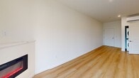 Located at 8005 NE 13th Ave in Vancouver, WA, this thoughtfully designed one-bedroom, one-bathroom unit offers a clean, modern aesthetic throughout its efficiently organized single-floor layout. Light hardwood-style flooring flows seamlessly through the living spaces, complementing the bright white walls and recessed lighting that give the unit an open, airy feel.

The open-concept kitchen, dining, and living area serves as the heart of the home. The kitchen is outfitted with grey shaker-style cabinetry, quartz countertops with a bold veining pattern, a white subway tile backsplash, and a full suite of stainless steel appliances including a refrigerator, range, microwave, and dishwasher. A center island with matching quartz provides additional prep and dining space.

The living area features a wall-mounted electric fireplace and a glass door that opens to the outdoors, allowing natural light to fill the room. The bedroom offers a comfortable footprint with a closet, a wall-mounted mini-split HVAC unit, and a window overlooking the surrounding greenery. The bathroom includes a full tub and shower combo with brushed nickel fixtures. Additional conveniences include a dedicated laundry area, a pantry, and two closets.