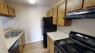 Located at 66 Daughtrey Ave in Waco, TX, this single-floor unit offers a well-organized layout with a variety of practical features throughout. The living room serves as the heart of the home, showcasing durable wood-look flooring, a ceiling fan with light fixture, and a classic brick fireplace that adds a warm, focal point to the space. Natural light pours in through a sliding glass door that opens to an outdoor balcony, offering open views of the surrounding area. An adjacent room features the same wood-look flooring and additional natural light, providing flexible living or dining space. The kitchen is efficiently designed with warm-toned wood cabinetry, speckled countertops, a built-in sink, and black appliances including a refrigerator and electric range with overhead ventilation. The bedrooms are carpeted for comfort and each include ceiling fans and windows that bring in natural light. The bathroom features a tiled tub-shower combination with a decorative accent border, a wood-toned vanity with speckled countertop, and wood-look flooring that ties the space together. This unit provides a functional and comfortable layout suited for everyday living in Waco, TX.