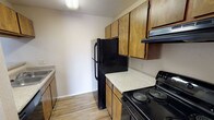 Located at 66 Daughtrey Ave in Waco, TX, this single-floor unit offers a well-organized layout with a variety of practical features throughout. The living room serves as the heart of the home, showcasing durable wood-look flooring, a ceiling fan with light fixture, and a classic brick fireplace that adds a warm, focal point to the space. Natural light pours in through a sliding glass door that opens to an outdoor balcony, offering open views of the surrounding area. An adjacent room features the same wood-look flooring and additional natural light, providing flexible living or dining space. The kitchen is efficiently designed with warm-toned wood cabinetry, speckled countertops, a built-in sink, and black appliances including a refrigerator and electric range with overhead ventilation. The bedrooms are carpeted for comfort and each include ceiling fans and windows that bring in natural light. The bathroom features a tiled tub-shower combination with a decorative accent border, a wood-toned vanity with speckled countertop, and wood-look flooring that ties the space together. This unit provides a functional and comfortable layout suited for everyday living in Waco, TX.