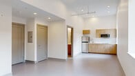Located at 547 River St in Troy, NY, this thoughtfully designed single-floor unit offers a clean, modern aesthetic with an open and functional layout. The main living area is bright and airy, featuring soaring ceilings with recessed lighting, smooth light-toned flooring throughout, and crisp white walls that enhance the sense of openness. A window with blinds allows natural light to filter into the space.

The kitchenette is efficiently appointed with warm wood-toned cabinetry, upper and lower storage, a stainless steel refrigerator, microwave, and a sink — providing all essential amenities in a compact, well-organized footprint. The open-concept arrangement of the main living and kitchen areas promotes a versatile use of space.

Two closets offer generous storage solutions, including a set of double doors ideal for larger items. The bathroom is clean and simply finished, with white walls, neutral flooring, and a curtain rod for a shower or tub area. A hallway with panel-style doors connects the various areas of the unit seamlessly.

Throughout the space, the design prioritizes functionality and simplicity, with a neutral color palette, modern fixtures, and quality finishes that create a fresh, contemporary atmosphere suited for practical, comfortable living.
