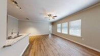This single-story, 2-bedroom, 1-bathroom home offers a thoughtfully designed layout across a comfortable footprint. The open-concept kitchen and living room serve as the heart of the space, featuring warm wood-look flooring, crown molding, and a ceiling fan with light kit. Large windows dressed with horizontal blinds invite abundant natural light, creating a bright and airy atmosphere. The kitchen is highlighted by rich dark wood cabinetry, a subway tile backsplash, stainless steel appliances including a refrigerator with ice maker and microwave, and a peninsula with granite countertops and a double-basin sink — ideal for both cooking and casual dining.

The primary bedroom is a generously sized retreat with plush carpet flooring, a ceiling fan, and dual windows that bring in natural light. The second bedroom also features soft carpeting and neutral tones. A dedicated closet provides convenient storage. The bathroom includes a full tub-shower combo with a curved curtain rod, granite-topped vanity, and wood-look tile flooring. The laundry room offers built-in shelving and hardwood-style flooring with washer and dryer hookups. Crown molding and neutral warm-toned walls are consistent throughout, lending the entire home a cohesive and polished feel.