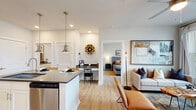 Located at 160 S Mattie M Kelly Blvd in Destin, Florida, this thoughtfully designed one-bedroom, one-bathroom residence offers a well-utilized single-floor layout. The open-concept living area is anchored by light wood-style flooring and large windows that flood the space with natural light, complemented by a ceiling fan overhead. A comfortable living room flows seamlessly into the combined dining and kitchen area, making the layout ideal for both relaxing and entertaining.

The kitchen is a standout feature, showcasing white shaker cabinetry, dark countertops, a classic white subway tile backsplash, and a suite of stainless steel appliances including a range, microwave, and French door refrigerator. A central island with pendant lighting provides additional prep space and casual bar seating.

The bedroom is a serene retreat, bathed in natural light from large windows and featuring a ceiling fan, two closets for ample storage, and a quiet, restful ambiance. The hallway leads to a well-appointed full bathroom with white cabinetry and dark countertops, as well as a dedicated in-unit laundry area with stacked washer and dryer.

A private patio and a separate pantry round out this efficiently designed home, offering practicality and comfort in the heart of Destin.