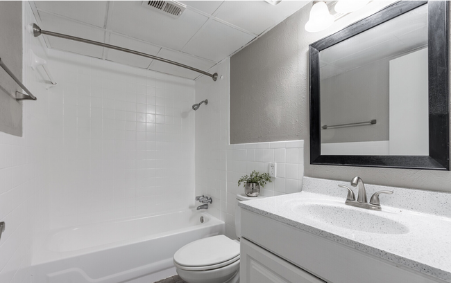 Un baño elegante y renovado con toques modernos y amplia iluminación. - Arbor Park Apartments