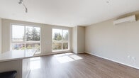 Located at 505 Lincoln Ave in San Jose, California, this single-floor unit offers a thoughtfully designed layout with modern finishes throughout. The open-concept living area is defined by large windows that frame views of surrounding greenery, flooding the space with natural light and creating a bright, welcoming atmosphere. Wood-style flooring runs continuously throughout, adding warmth and visual cohesion to every room.

The kitchen serves as a functional centerpiece, featuring warm wood cabinetry, white quartz countertops, and a glass tile backsplash. Stainless steel appliances—including a range, over-the-range microwave, and refrigerator—complement the contemporary design. A central island provides additional prep space and casual seating potential. Track lighting and recessed fixtures ensure ample illumination.

The living area offers generous proportions, with clean neutral walls and abundant sunlight streaming in from oversized windows. A dedicated hallway connects the main living spaces to the private areas of the unit, which include a bathroom equipped with a full soaking tub and shower combination, chrome fixtures, and crisp white surroundings. In-unit laundry facilities are also present. The overall design aesthetic is clean, modern, and functional, making this a well-appointed space in the heart of San Jose.