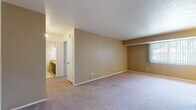 This single-floor residence at 5286 Clubhouse Dr in North Olmsted, Ohio, offers a straightforward and functional layout designed for comfortable everyday living. The living and dining areas are finished with wall-to-wall carpeting in a neutral tone, complemented by warm beige walls that create a cohesive, understated atmosphere throughout. A large window fitted with vertical blinds allows natural light to fill the dining area, which is anchored by a classic chandelier overhead. The open flow between the living and dining spaces provides a generous sense of room and versatility for various furniture arrangements.

The galley-style kitchen is well-equipped, featuring dark brown cabinetry lining both walls from floor to ceiling, offering abundant storage. Light-toned countertops, a stainless steel sink, a white refrigerator, and an electric range complete the kitchen's practical setup. Wood-look flooring runs underfoot, adding warmth and durability to the space.

The bedroom is notably spacious, benefiting from dual closets with bifold doors that provide ample storage capacity. An adjacent bathroom includes a vanity with warm-toned cabinetry and overhead lighting. Overall, the residence presents a clean, move-in-ready environment with consistent finishes and practical storage solutions throughout.