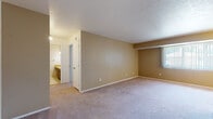 This single-floor residence at 5286 Clubhouse Dr in North Olmsted, Ohio, offers a straightforward and functional layout designed for comfortable everyday living. The living and dining areas are finished with wall-to-wall carpeting in a neutral tone, complemented by warm beige walls that create a cohesive, understated atmosphere throughout. A large window fitted with vertical blinds allows natural light to fill the dining area, which is anchored by a classic chandelier overhead. The open flow between the living and dining spaces provides a generous sense of room and versatility for various furniture arrangements.

The galley-style kitchen is well-equipped, featuring dark brown cabinetry lining both walls from floor to ceiling, offering abundant storage. Light-toned countertops, a stainless steel sink, a white refrigerator, and an electric range complete the kitchen's practical setup. Wood-look flooring runs underfoot, adding warmth and durability to the space.

The bedroom is notably spacious, benefiting from dual closets with bifold doors that provide ample storage capacity. An adjacent bathroom includes a vanity with warm-toned cabinetry and overhead lighting. Overall, the residence presents a clean, move-in-ready environment with consistent finishes and practical storage solutions throughout.